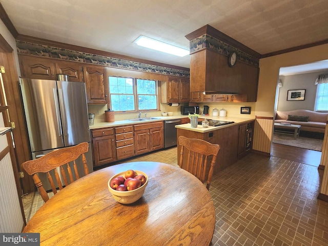 kitchen featuring ornamental molding, appliances with stainless steel finishes, a kitchen island, and sink