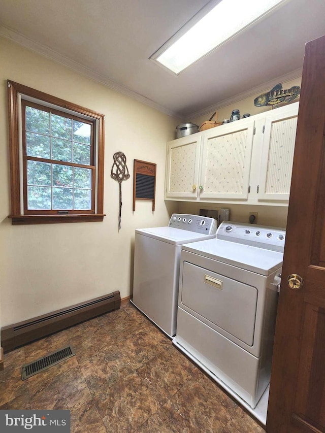 laundry area with cabinets, baseboard heating, and washing machine and clothes dryer