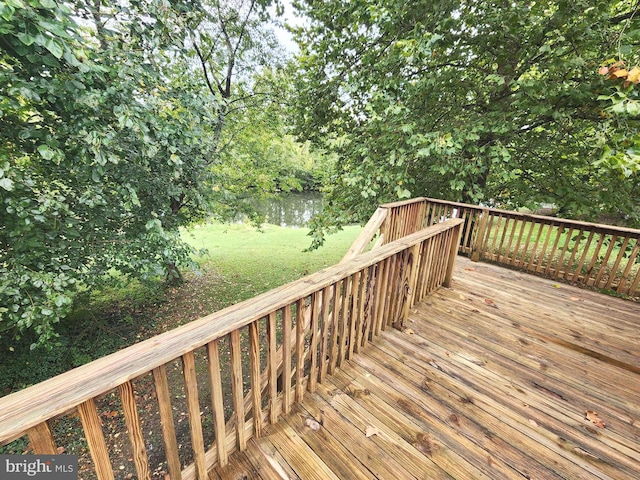 deck with a lawn and a water view