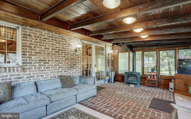 sunroom with wood ceiling, beamed ceiling, and a wood stove