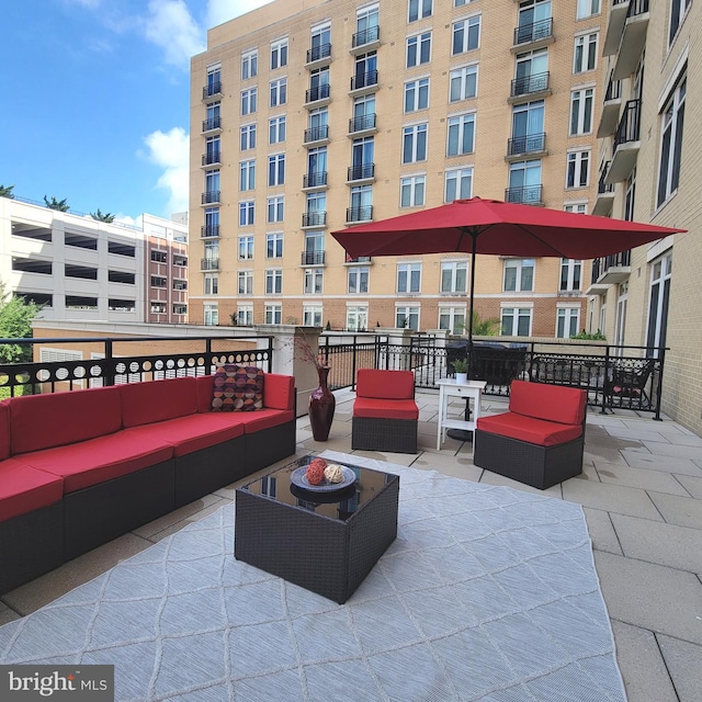 view of patio featuring a balcony and an outdoor living space with a fire pit