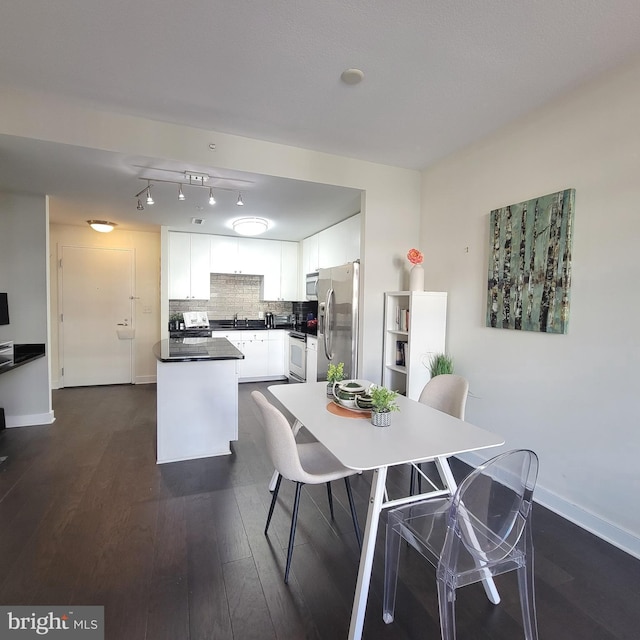 dining room featuring sink and dark hardwood / wood-style flooring