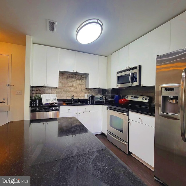 kitchen featuring stainless steel appliances, dark hardwood / wood-style floors, and white cabinetry