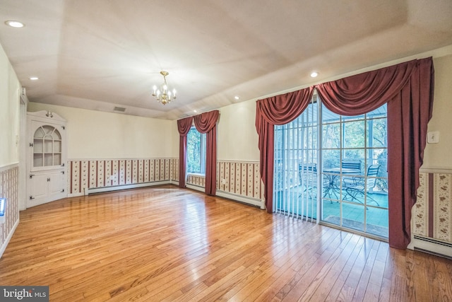 interior space with a notable chandelier, light hardwood / wood-style floors, and a healthy amount of sunlight