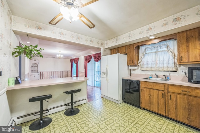 kitchen featuring ceiling fan with notable chandelier, black appliances, sink, and a baseboard radiator