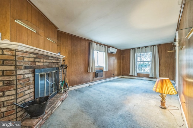 unfurnished living room featuring a wall mounted air conditioner, wood walls, carpet floors, and a brick fireplace