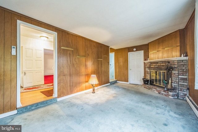 unfurnished living room with a brick fireplace, carpet flooring, and wood walls