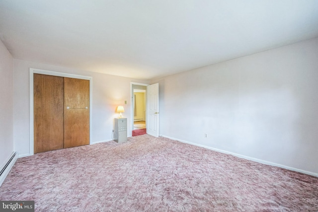 unfurnished bedroom featuring a closet, carpet, and baseboard heating