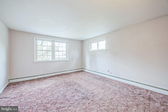 spare room with a healthy amount of sunlight, carpet flooring, and baseboard heating