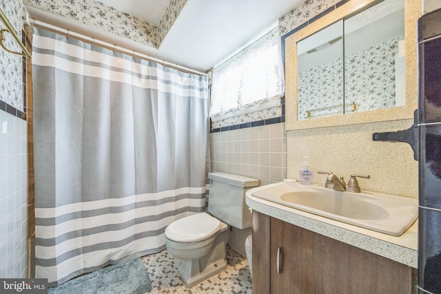 bathroom with tile walls, toilet, vanity, curtained shower, and tile patterned flooring