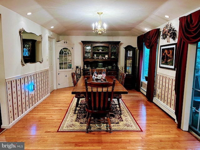 dining space featuring an inviting chandelier, light hardwood / wood-style flooring, and a baseboard heating unit