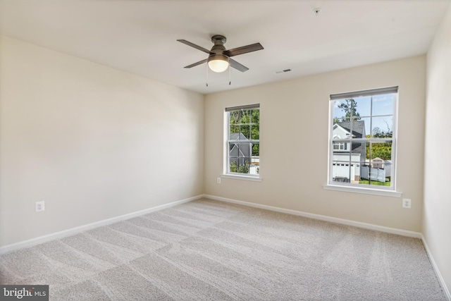 carpeted spare room featuring ceiling fan