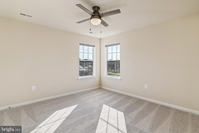 unfurnished room with ceiling fan and carpet