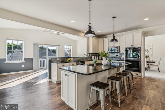 kitchen with ceiling fan, vaulted ceiling, dark hardwood / wood-style flooring, and black appliances