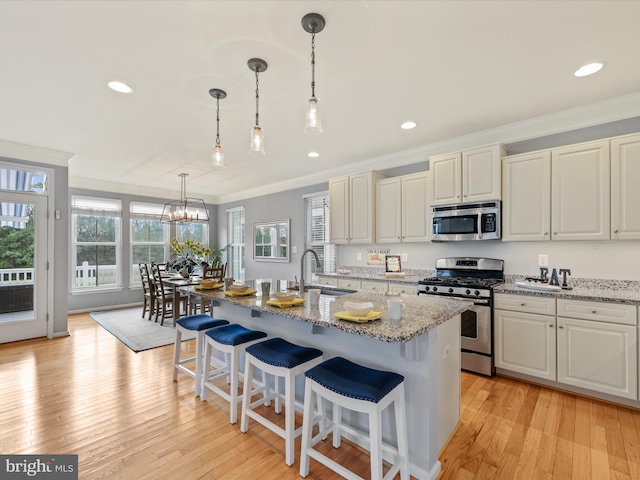 kitchen featuring light stone counters, light hardwood / wood-style floors, appliances with stainless steel finishes, and sink