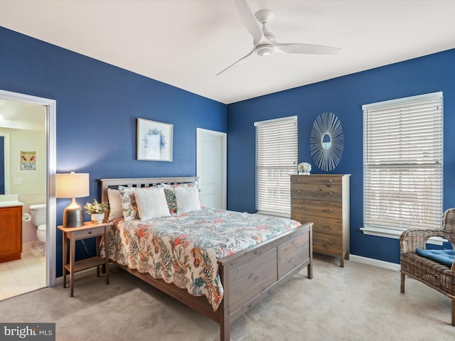 carpeted bedroom with ceiling fan and ensuite bath