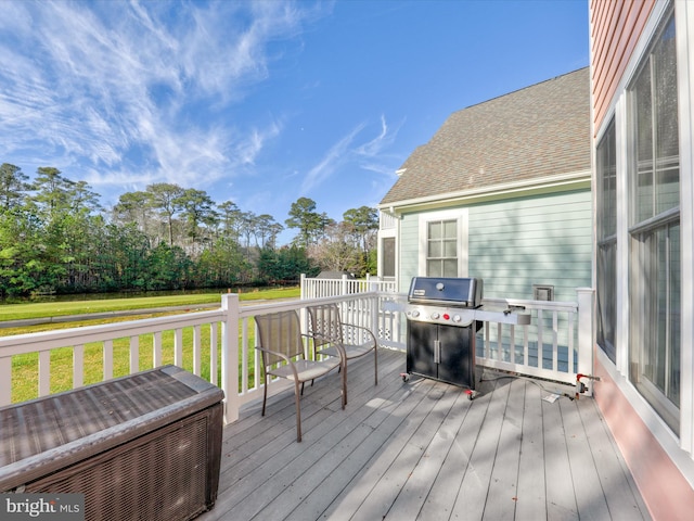 wooden terrace with a lawn and grilling area