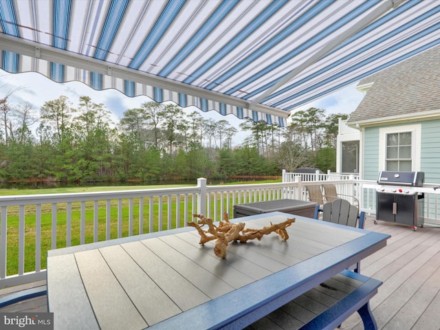 wooden deck featuring a yard and a grill