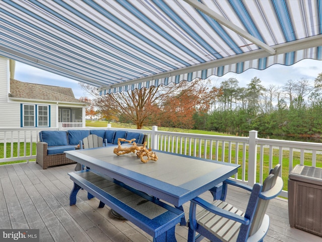 wooden deck with an outdoor hangout area and a lawn