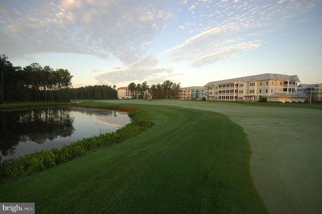 surrounding community with a lawn and a water view