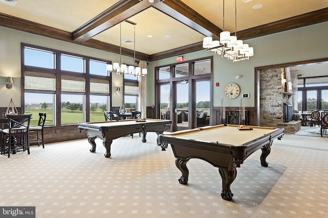 rec room with pool table, a notable chandelier, light colored carpet, a stone fireplace, and ornamental molding