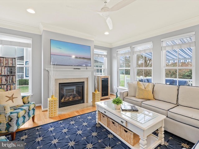 living room with ornamental molding, ceiling fan, hardwood / wood-style flooring, and a healthy amount of sunlight