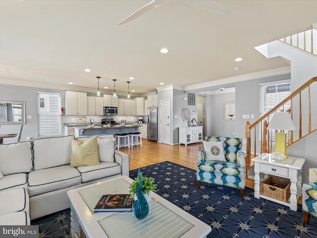 living room featuring ornamental molding and light hardwood / wood-style floors