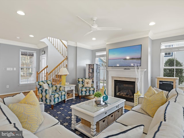 living room featuring crown molding, ceiling fan, a high end fireplace, and dark wood-type flooring