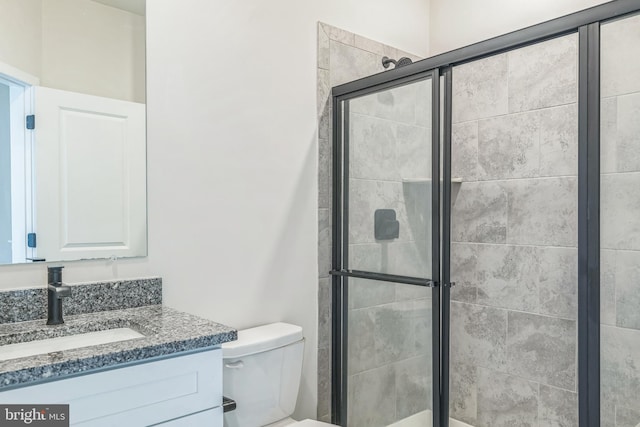 bathroom featuring walk in shower, vanity, and toilet