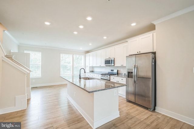 kitchen with light wood-style flooring, crown molding, light stone countertops, appliances with stainless steel finishes, and a sink