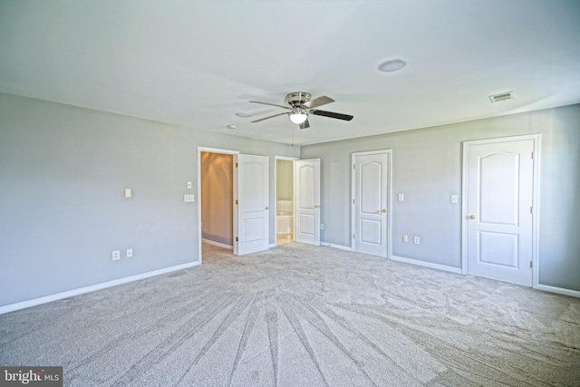 unfurnished bedroom featuring light carpet, ceiling fan, and ensuite bathroom