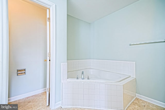 bathroom featuring tile patterned flooring and a relaxing tiled tub