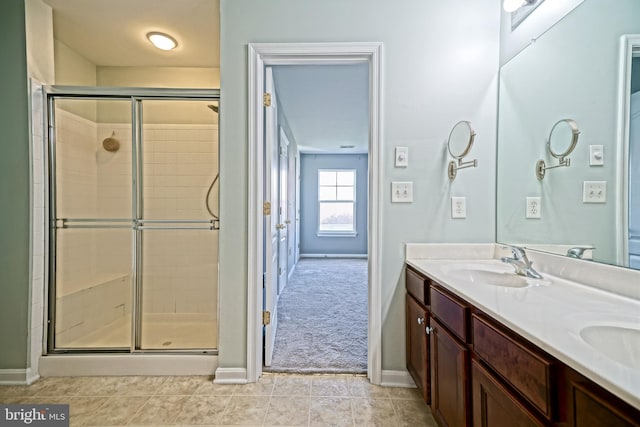 bathroom with a shower with door, tile patterned floors, and vanity