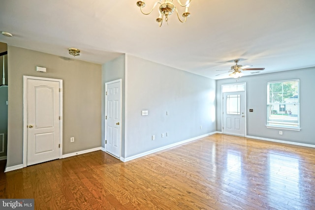 unfurnished room with wood-type flooring and ceiling fan with notable chandelier