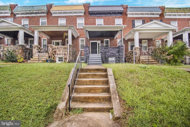 townhome / multi-family property with a front yard and a porch