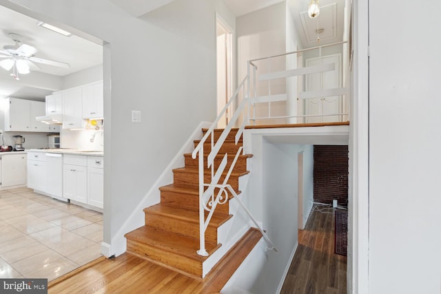 stairs featuring ceiling fan, hardwood / wood-style floors, and sink