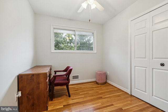 home office with light hardwood / wood-style flooring and ceiling fan