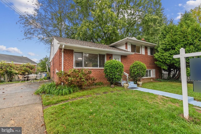 tri-level home with a front lawn