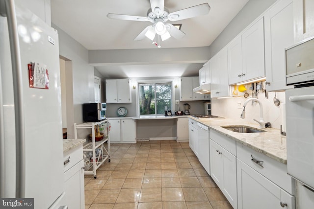 kitchen with white appliances, white cabinetry, sink, and ceiling fan