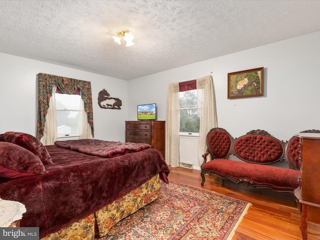 bedroom featuring a textured ceiling and hardwood / wood-style floors