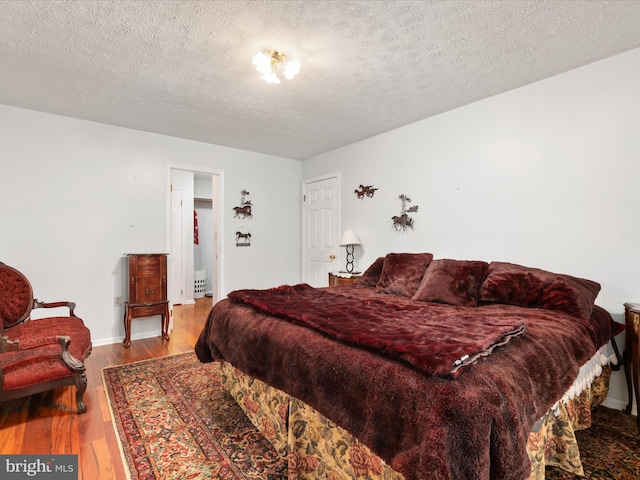 bedroom featuring a textured ceiling and light hardwood / wood-style flooring