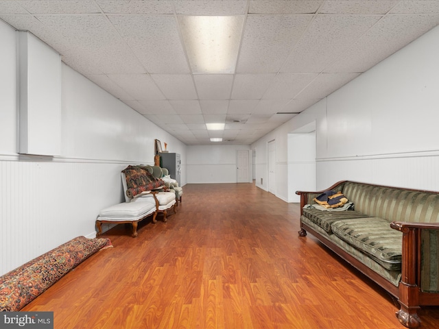 living area featuring hardwood / wood-style flooring and a paneled ceiling