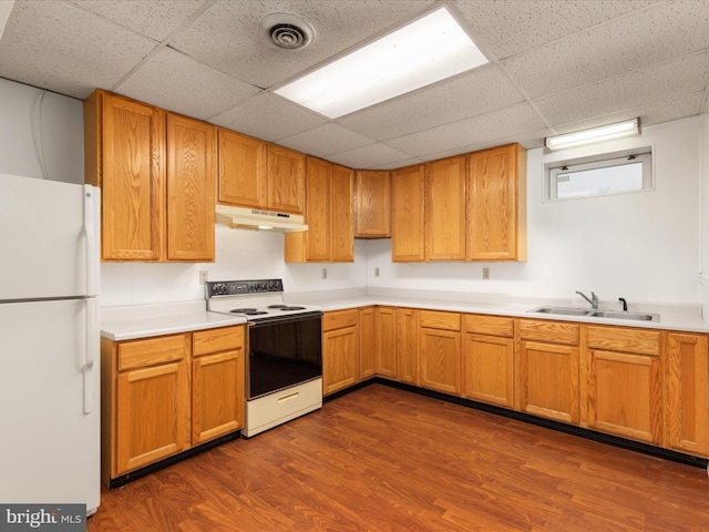 kitchen featuring white appliances, a paneled ceiling, dark wood-type flooring, and sink