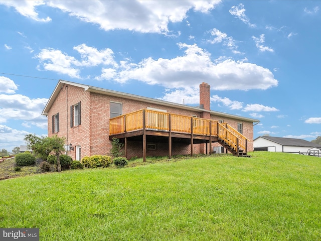 rear view of property featuring a wooden deck and a lawn