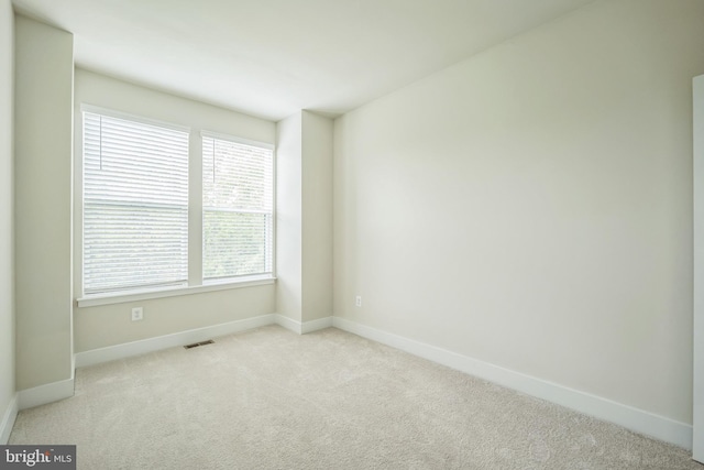 carpeted spare room with a healthy amount of sunlight