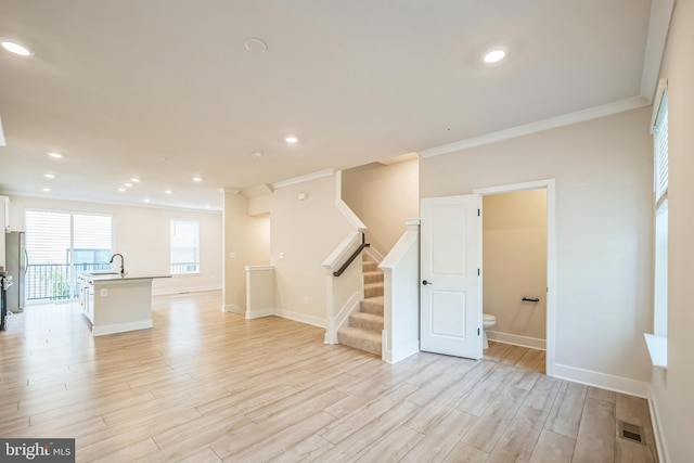 interior space featuring ornamental molding, sink, and light hardwood / wood-style floors