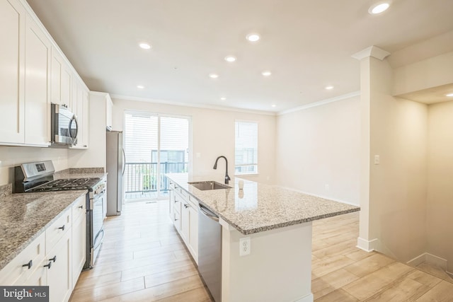 kitchen featuring light stone counters, sink, white cabinetry, a center island with sink, and appliances with stainless steel finishes