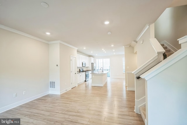 foyer entrance with crown molding, light hardwood / wood-style floors, and sink