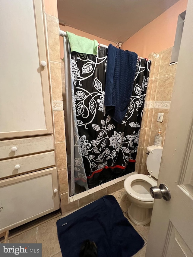 bathroom with toilet, a shower with curtain, and tile patterned flooring