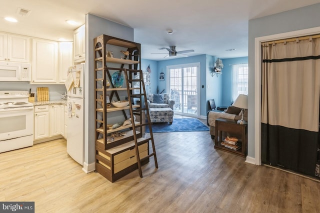 interior space with white cabinetry, ceiling fan, white appliances, and light hardwood / wood-style floors